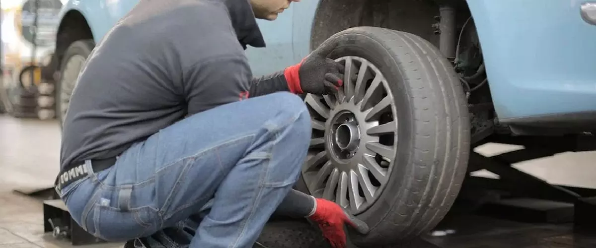 Mecánico cambiando rueda de auto.