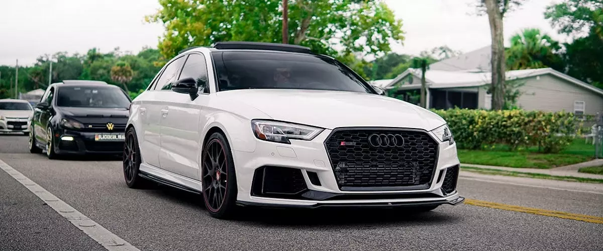 Auto blanco circulando por calle.